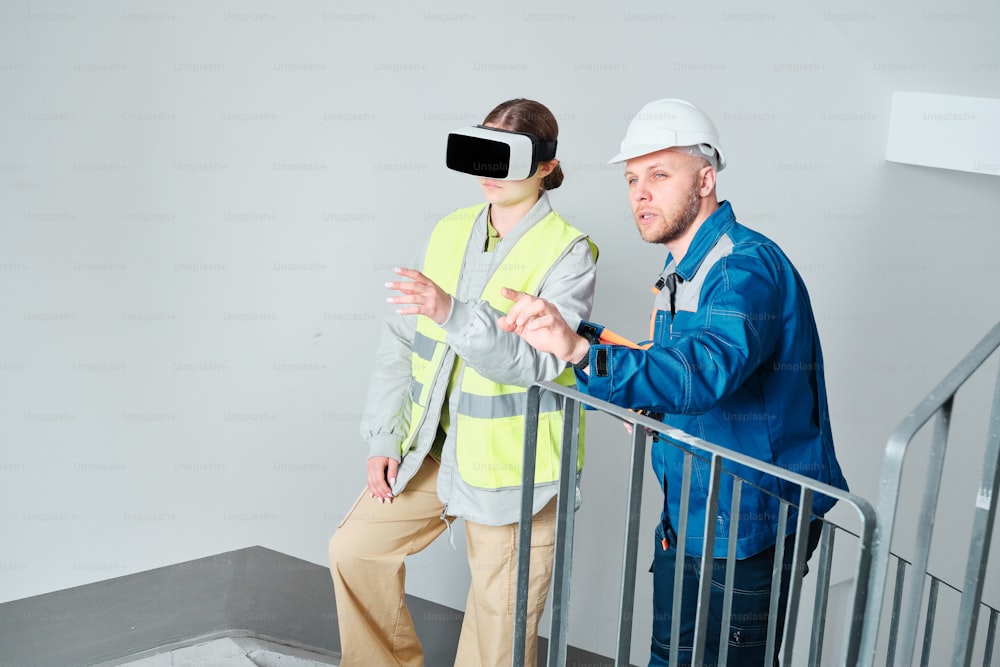 a man wearing a safety vest and a woman wearing a virtual headset
