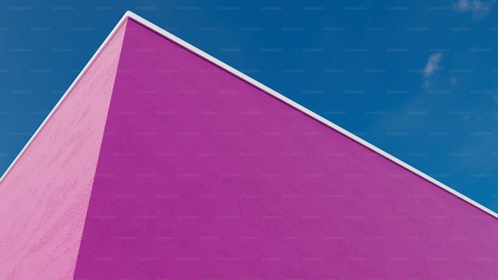 a pink building with a blue sky in the background