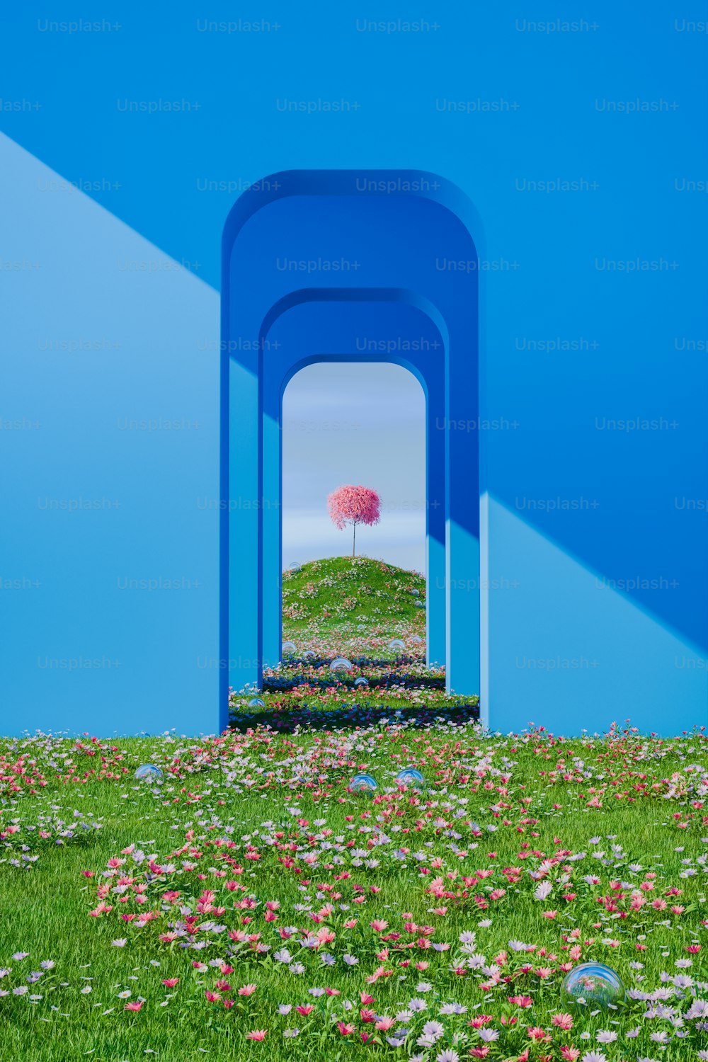 un albero rosa in mezzo a un campo di fiori