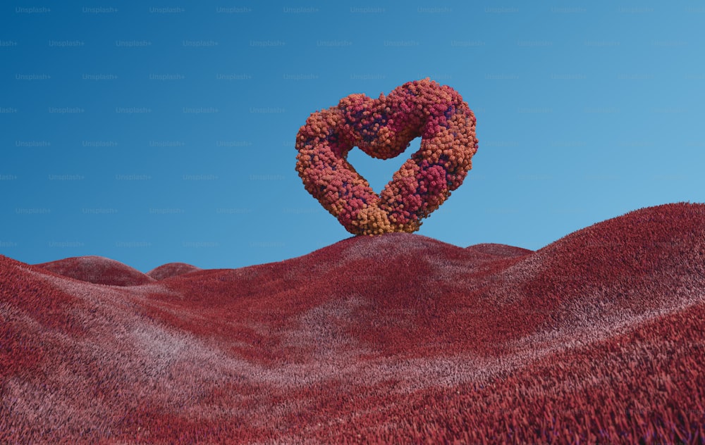 a heart shaped object sitting on top of a hill