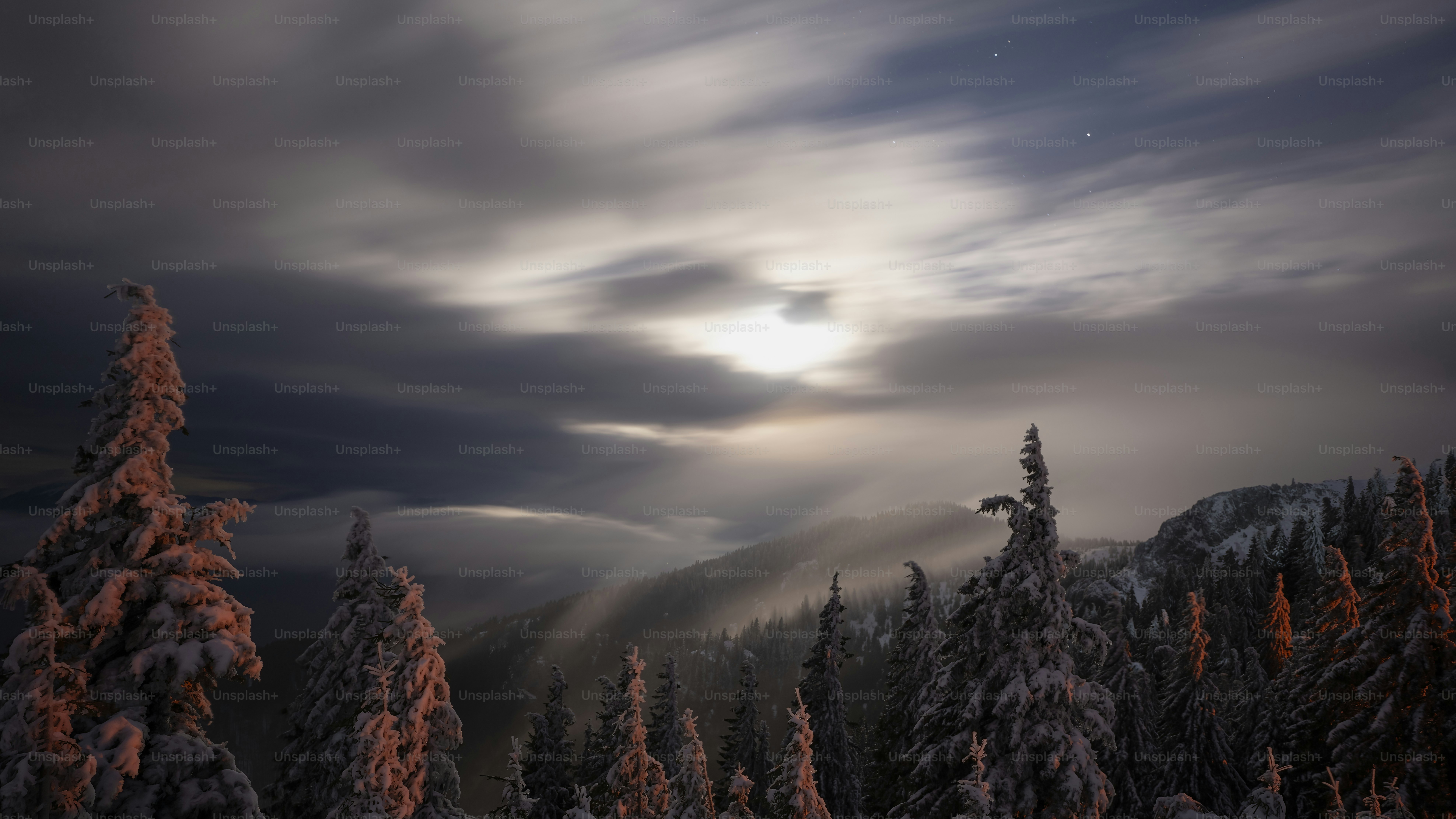 the sun is shining through the clouds over the trees
