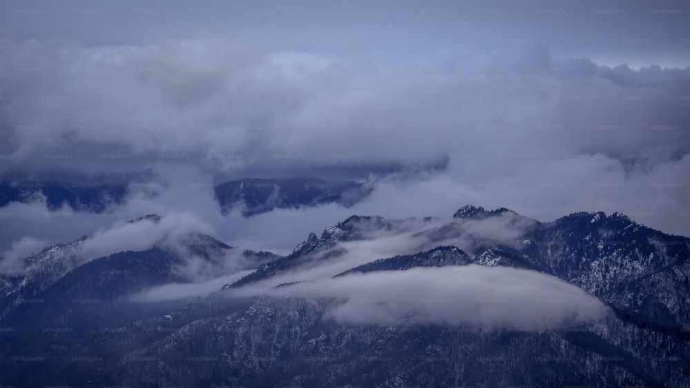 a view of a mountain range covered in clouds