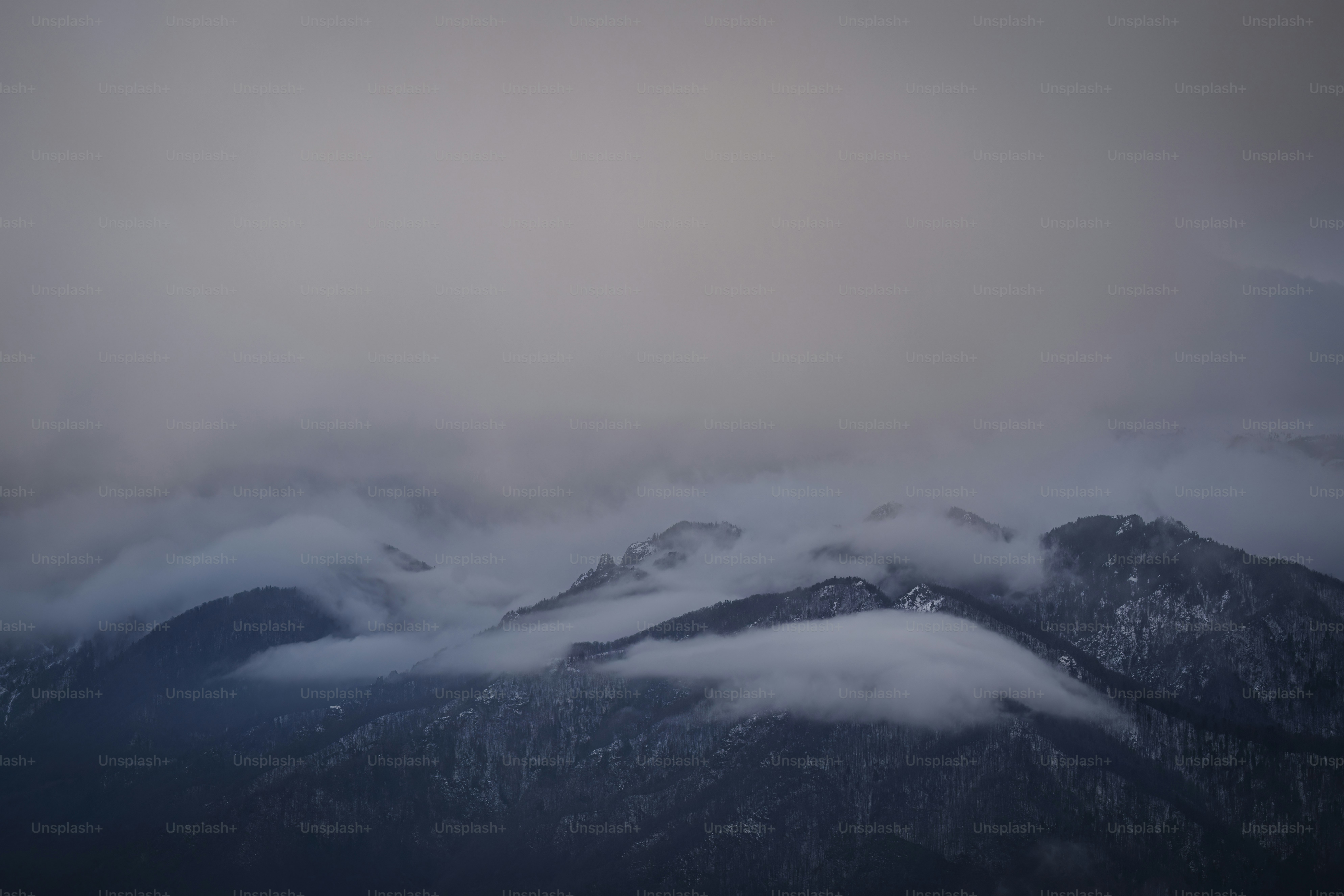 a view of a mountain covered in clouds