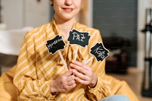 eine Frau sitzt auf einer Couch und hält ein Schild in der Hand