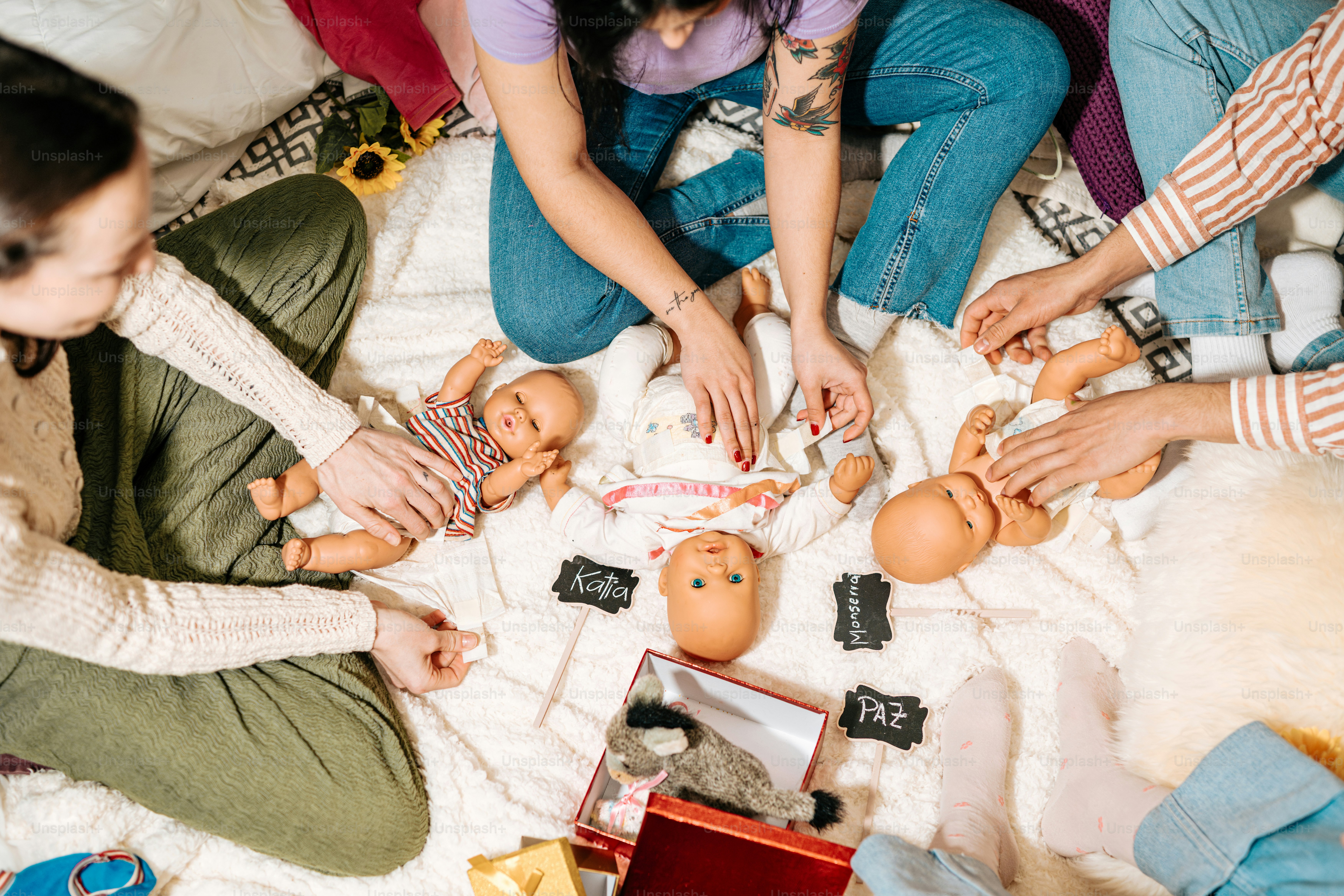 a group of people sitting on top of a white blanket
