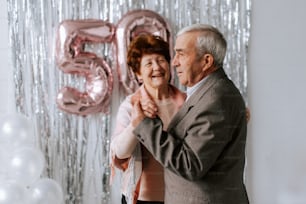 a man and woman dancing in front of balloons