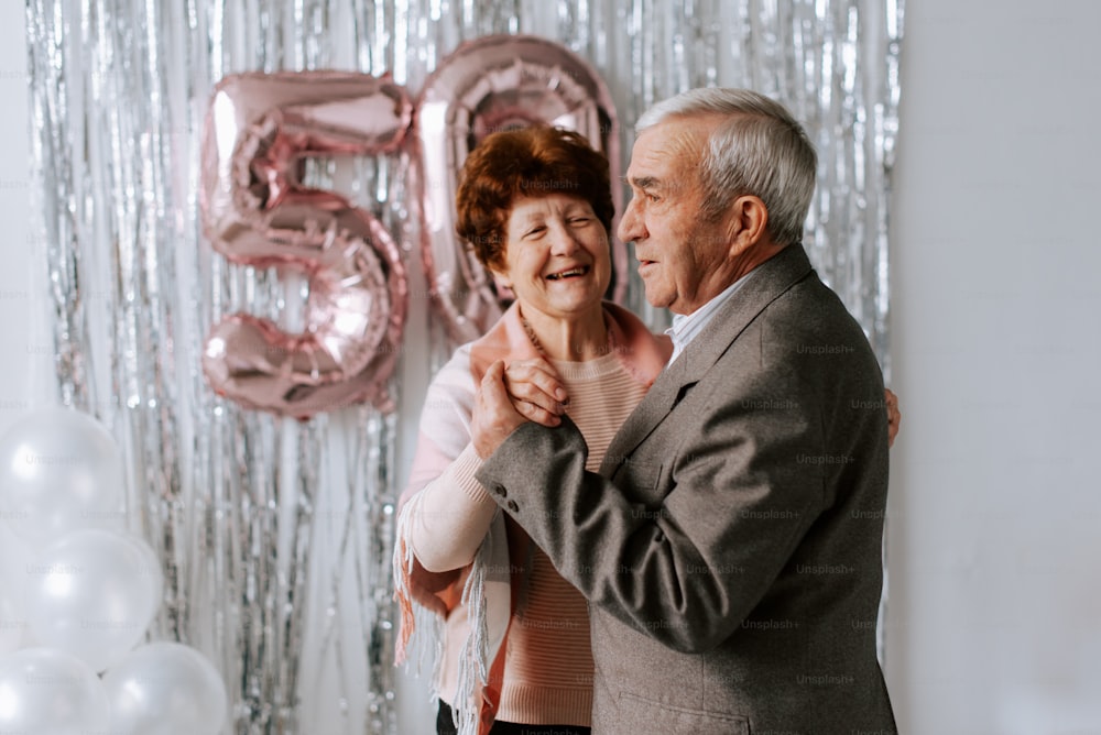 un hombre y una mujer bailando frente a globos