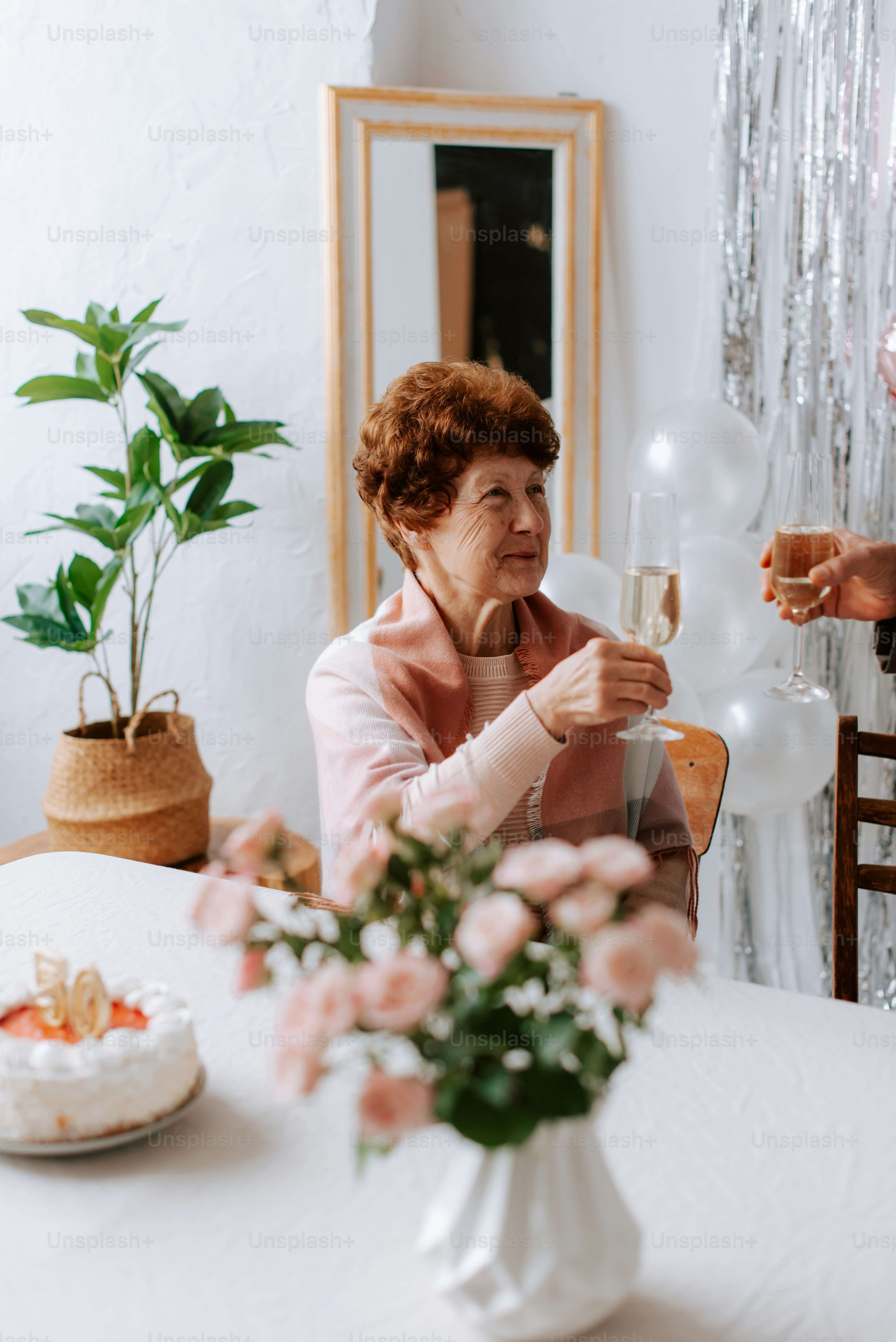 uma mulher sentada em uma mesa segurando uma taça de vinho