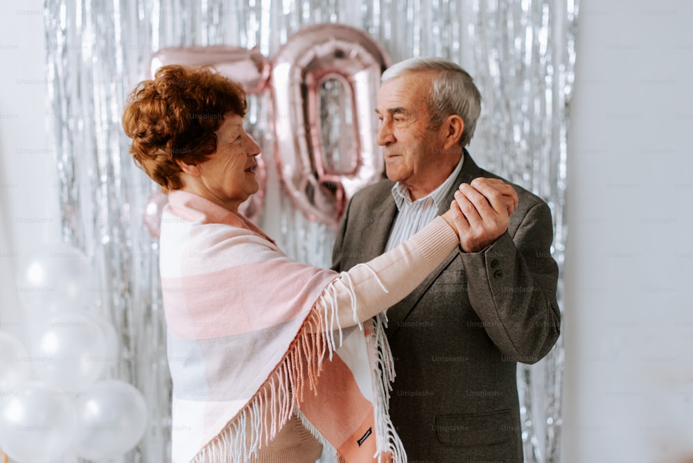 Un hombre y una mujer bailan juntos frente a globos