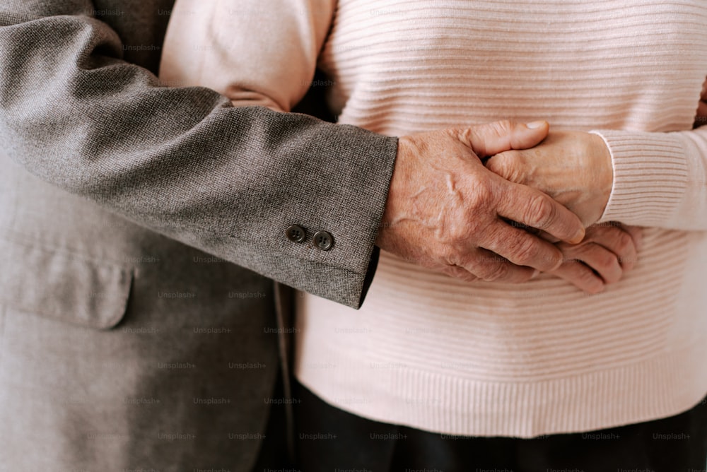 a close up of two people holding hands