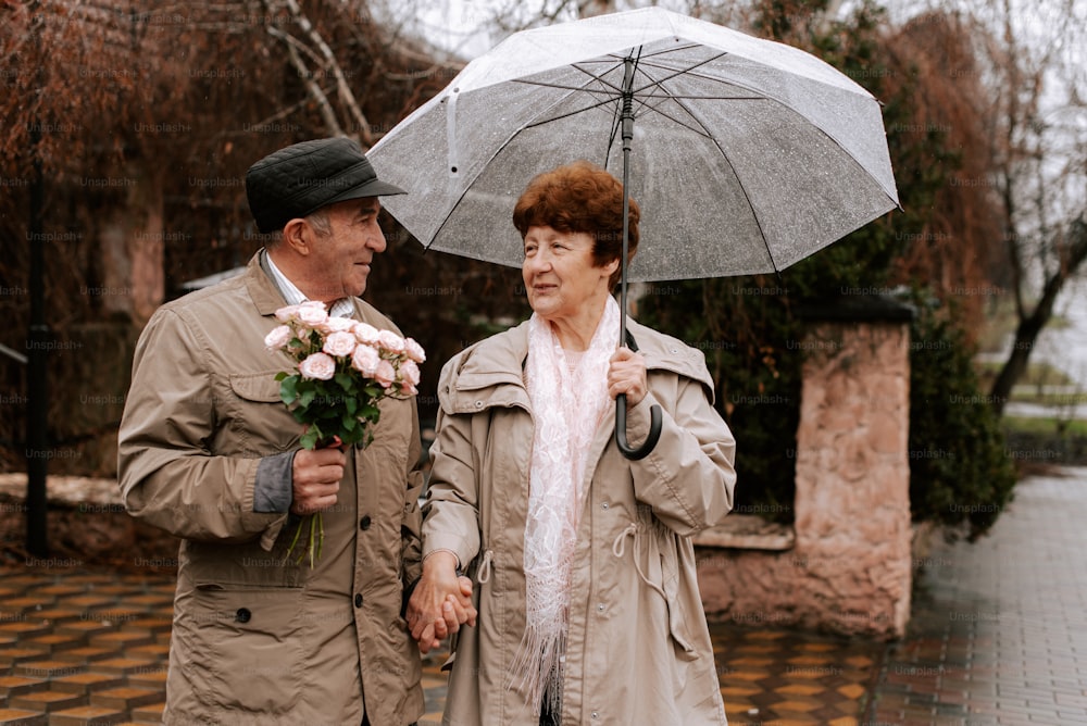 a man and a woman holding flowers under an umbrella