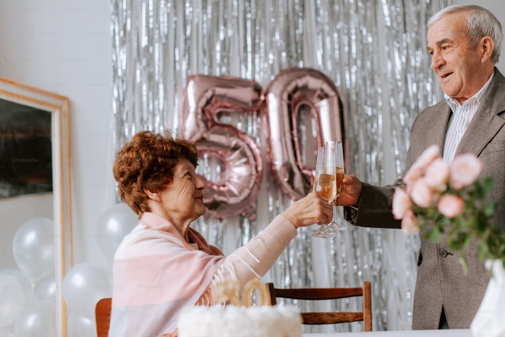 a man and woman toasting each other at a table