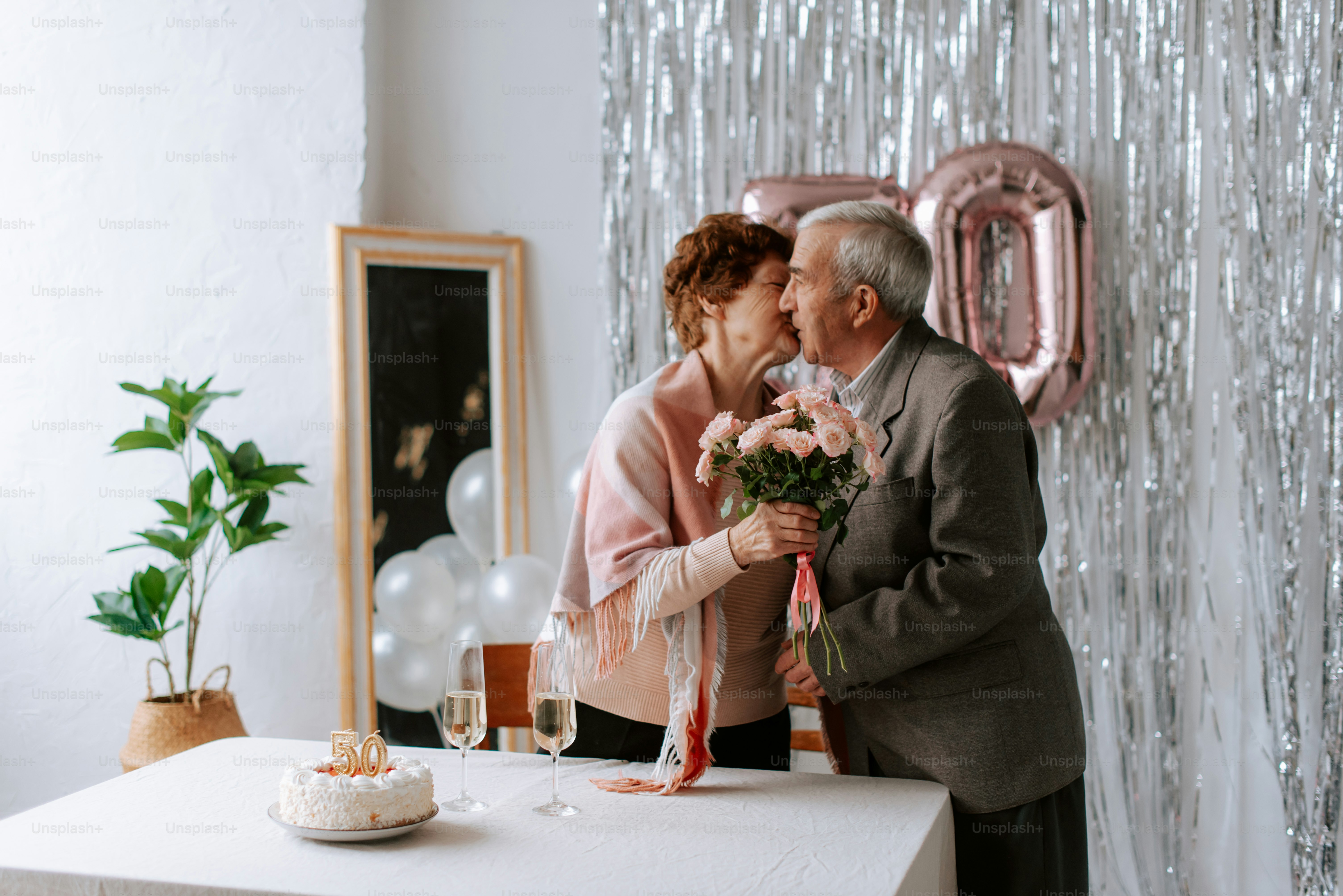 um homem e uma mulher ao lado de uma mesa com um bolo