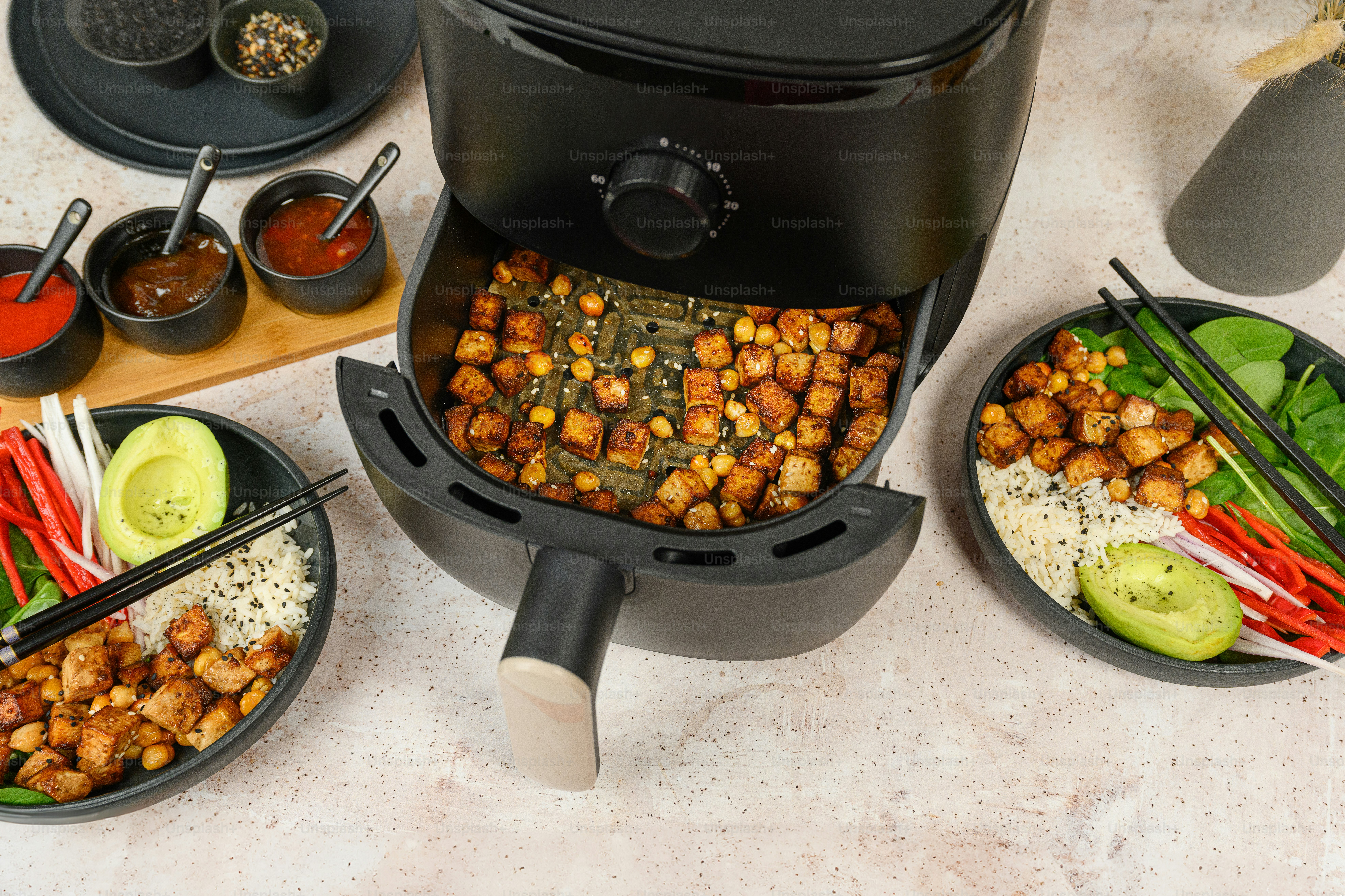 a table topped with plates of food next to a slow cooker