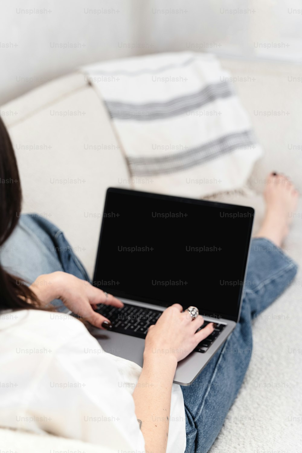 a woman sitting on a couch using a laptop computer