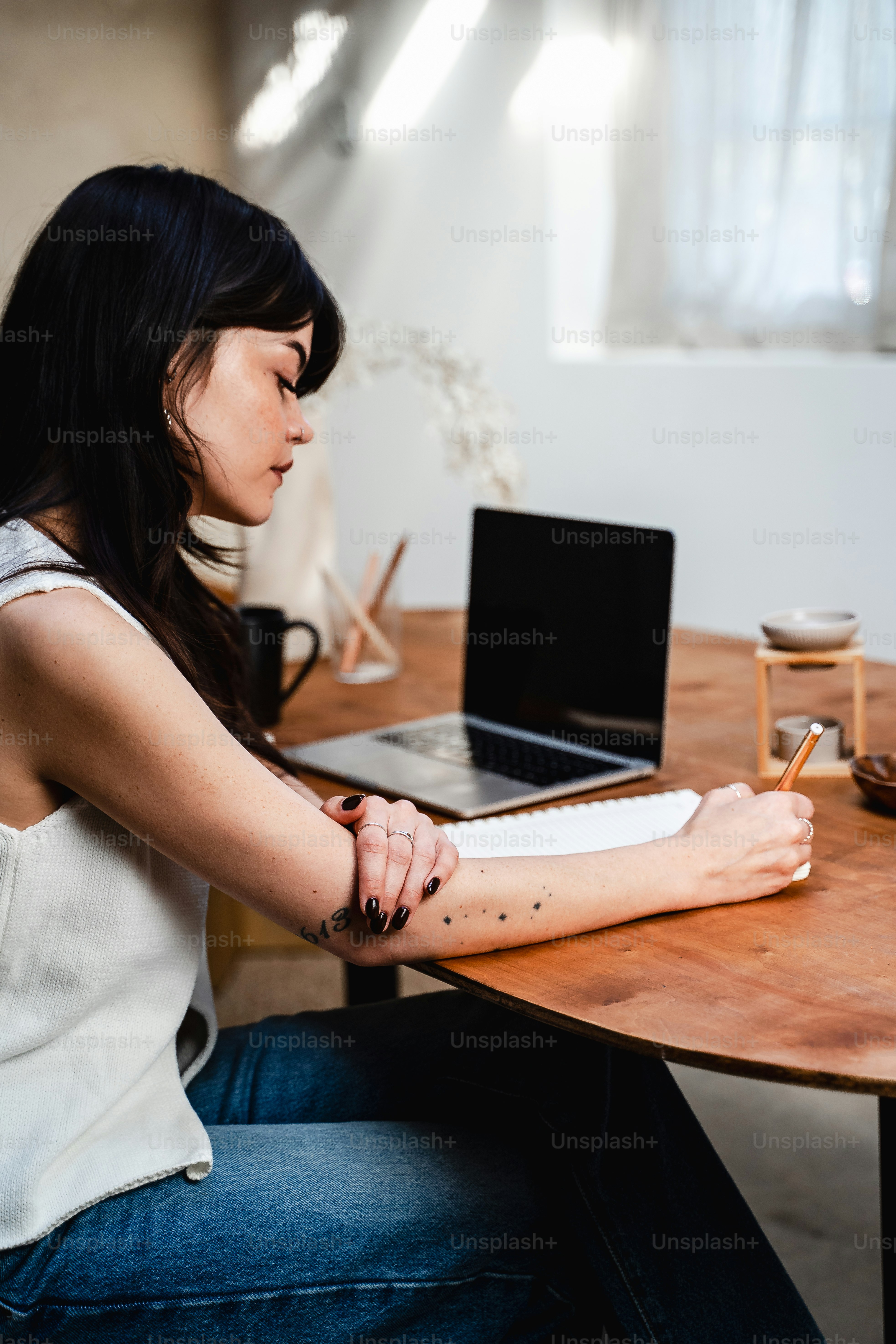 テーブルに座って紙に書く女性