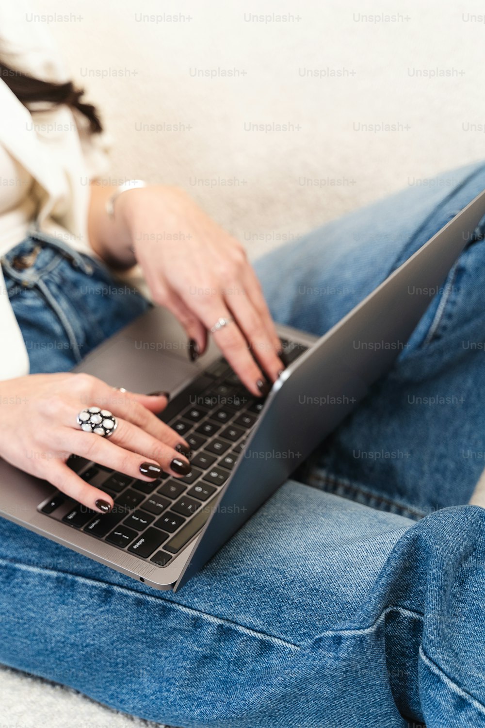 una mujer sentada en un sofá usando una computadora portátil
