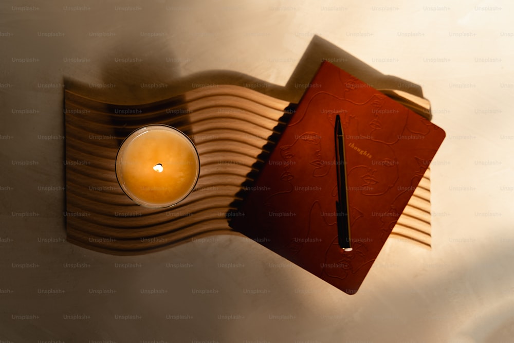 eine Kerze und ein Buch auf einem Tisch