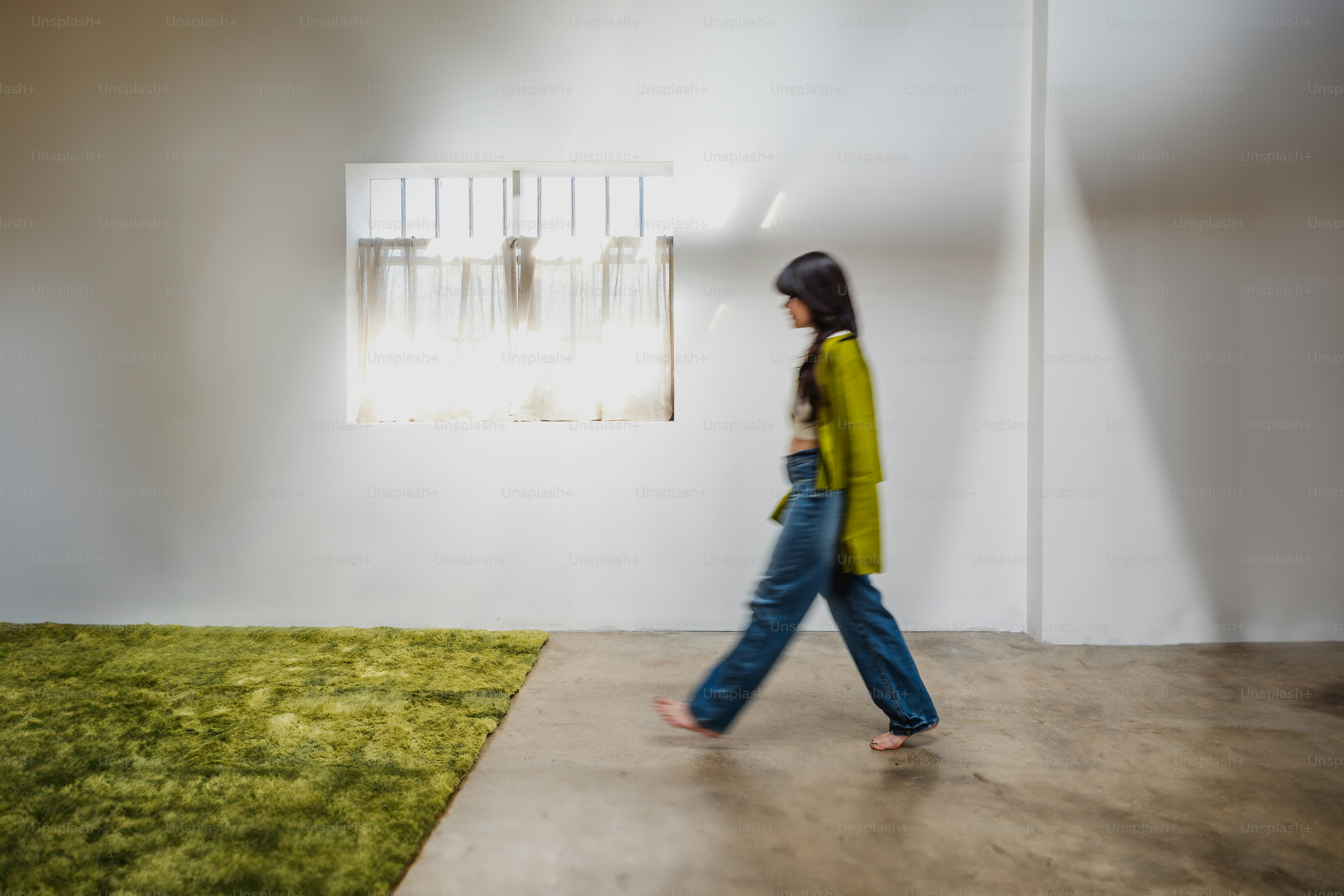 a woman walking past a window in a room
