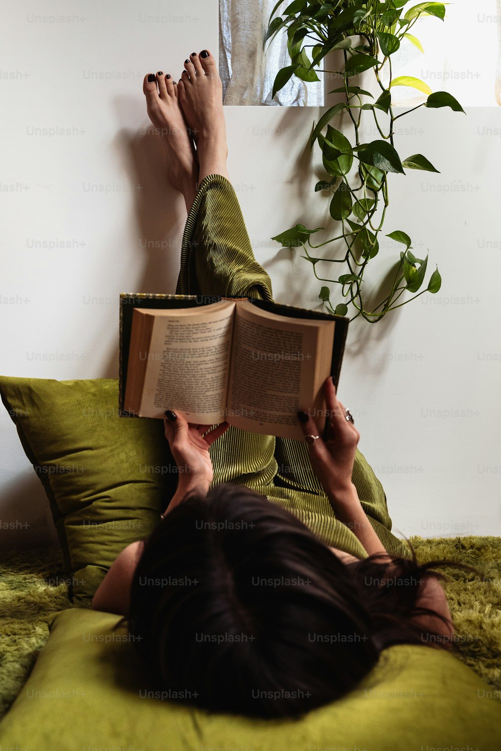 a woman laying on a bed reading a book