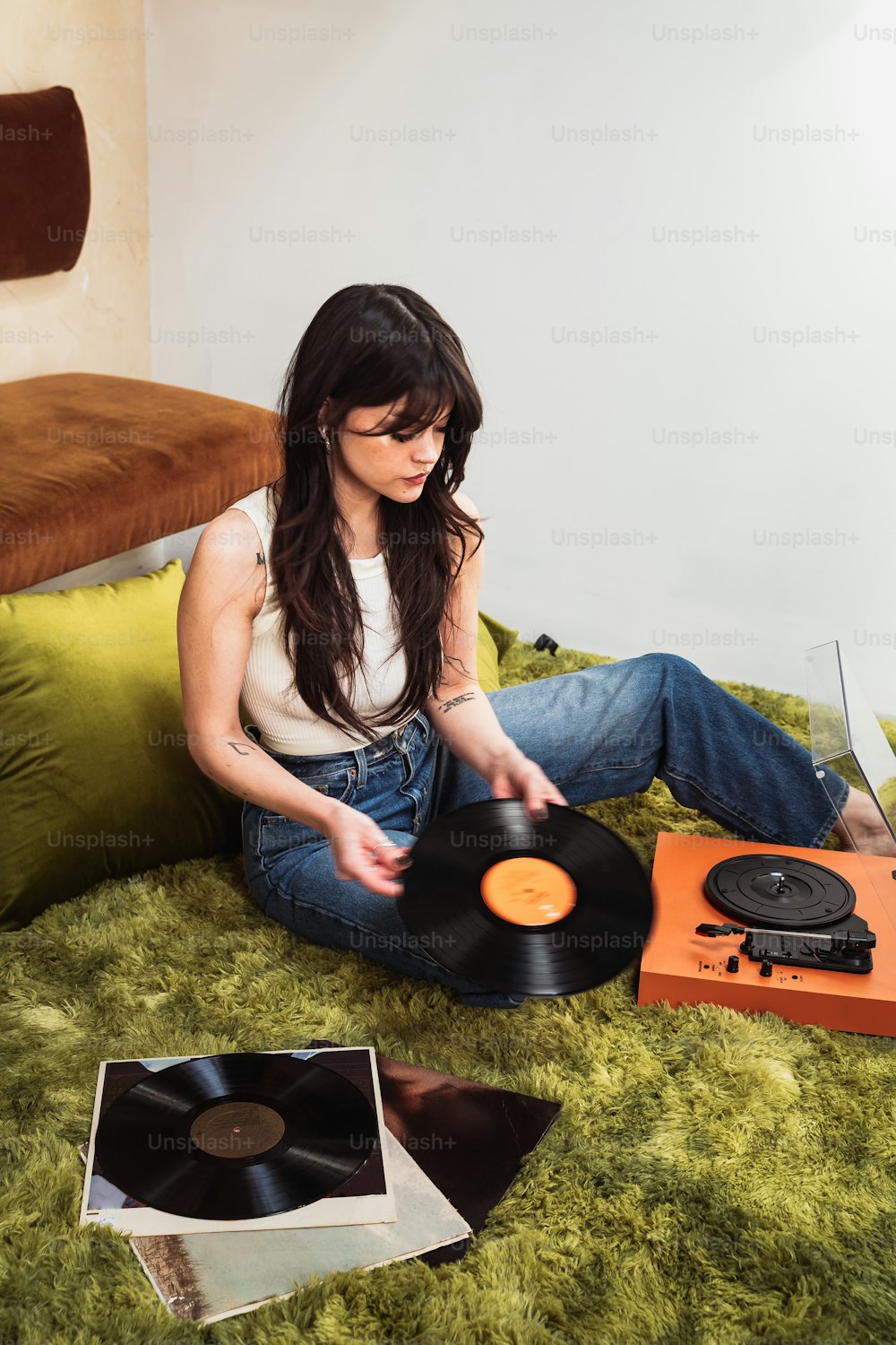 a woman sitting on a bed with a record player