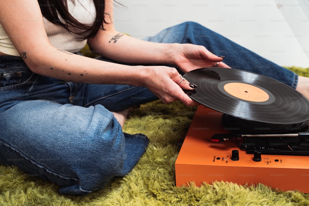 a woman sitting on the floor with a record player