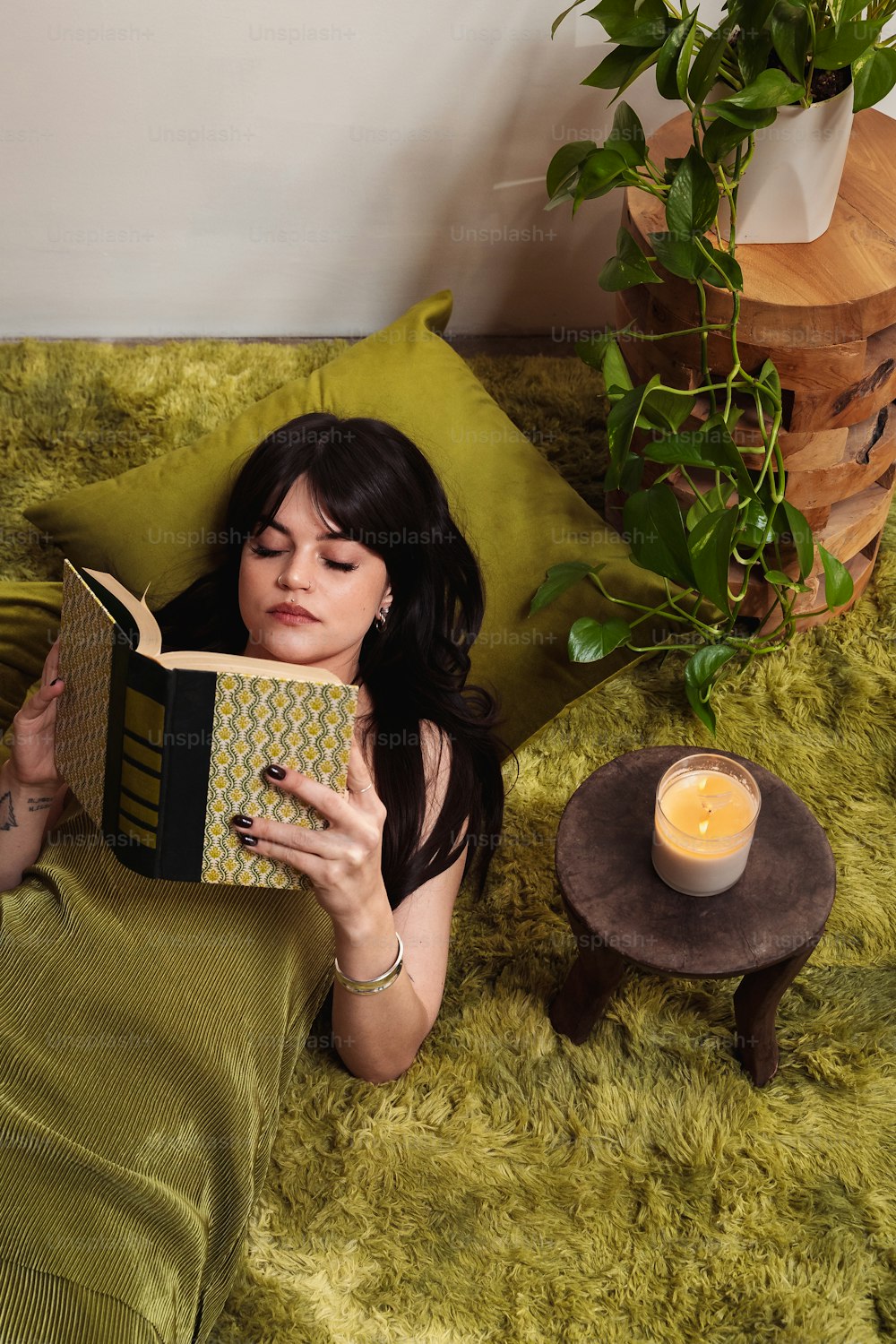 une femme allongée sur un lit lisant un livre