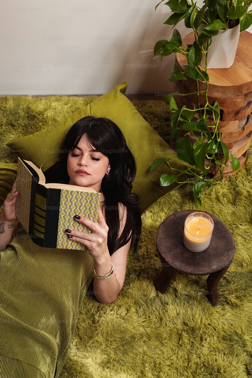 a woman laying on a bed reading a book