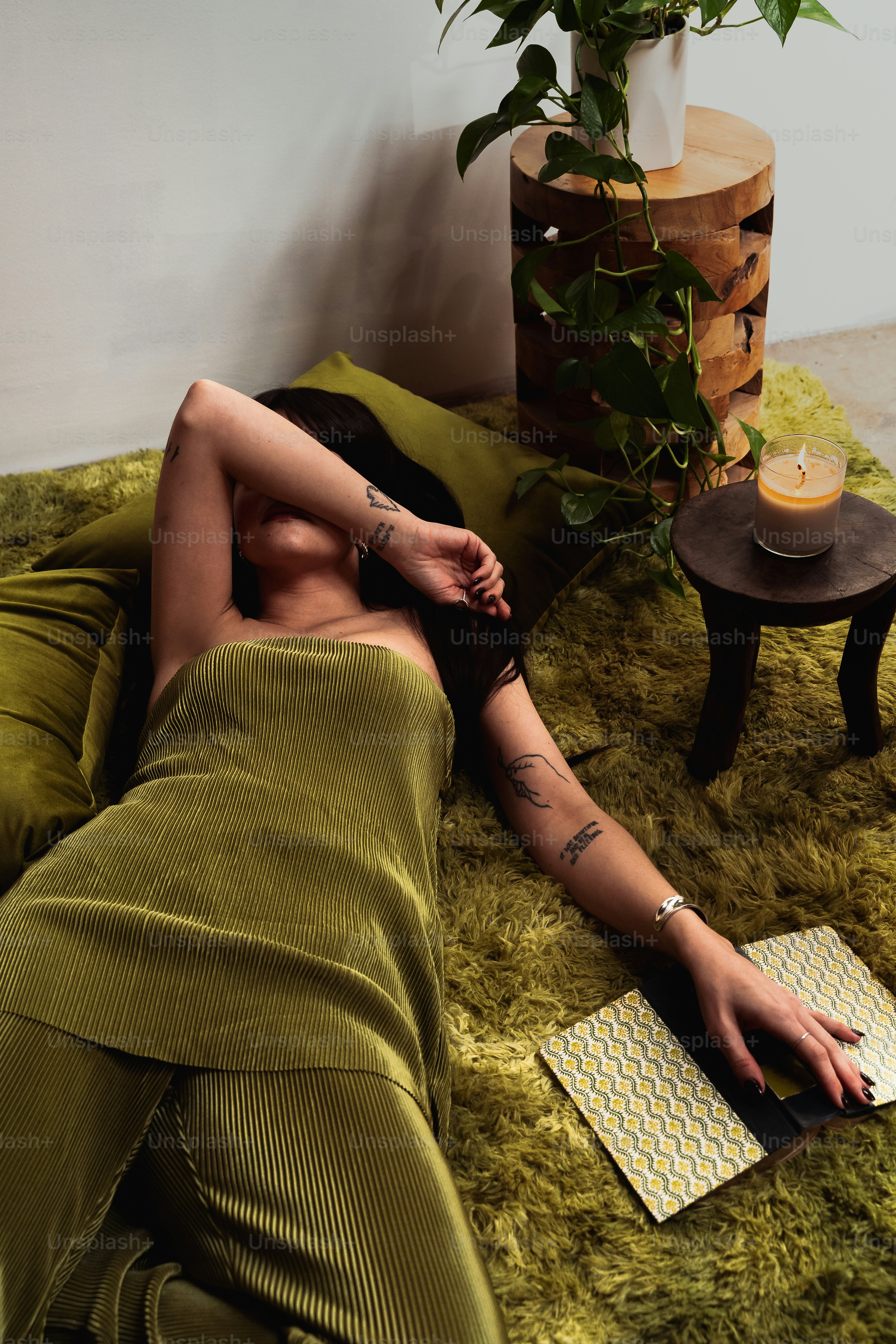 a woman laying on a bed next to a potted plant