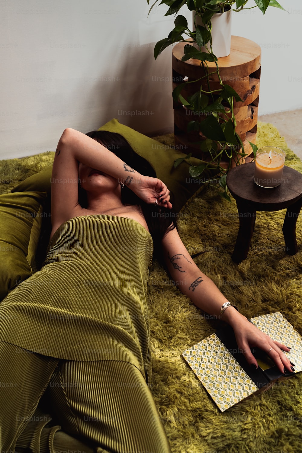a woman laying on a bed next to a potted plant
