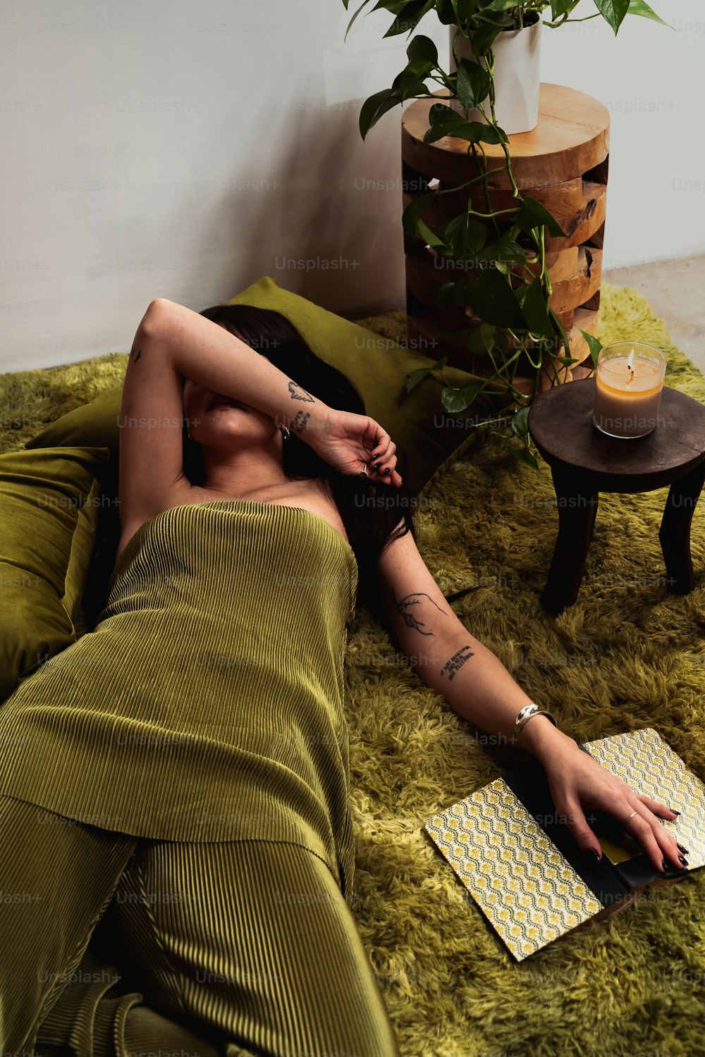 a woman laying on a bed next to a potted plant