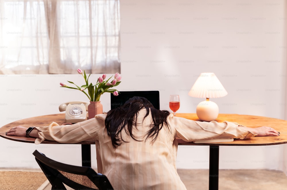 a woman sitting at a table with a laptop