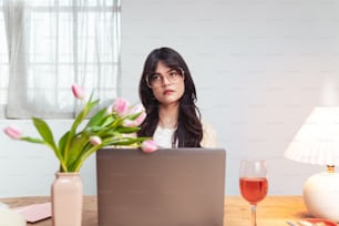 a woman sitting in front of a laptop computer