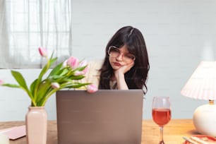 uma mulher sentada em frente a um computador portátil