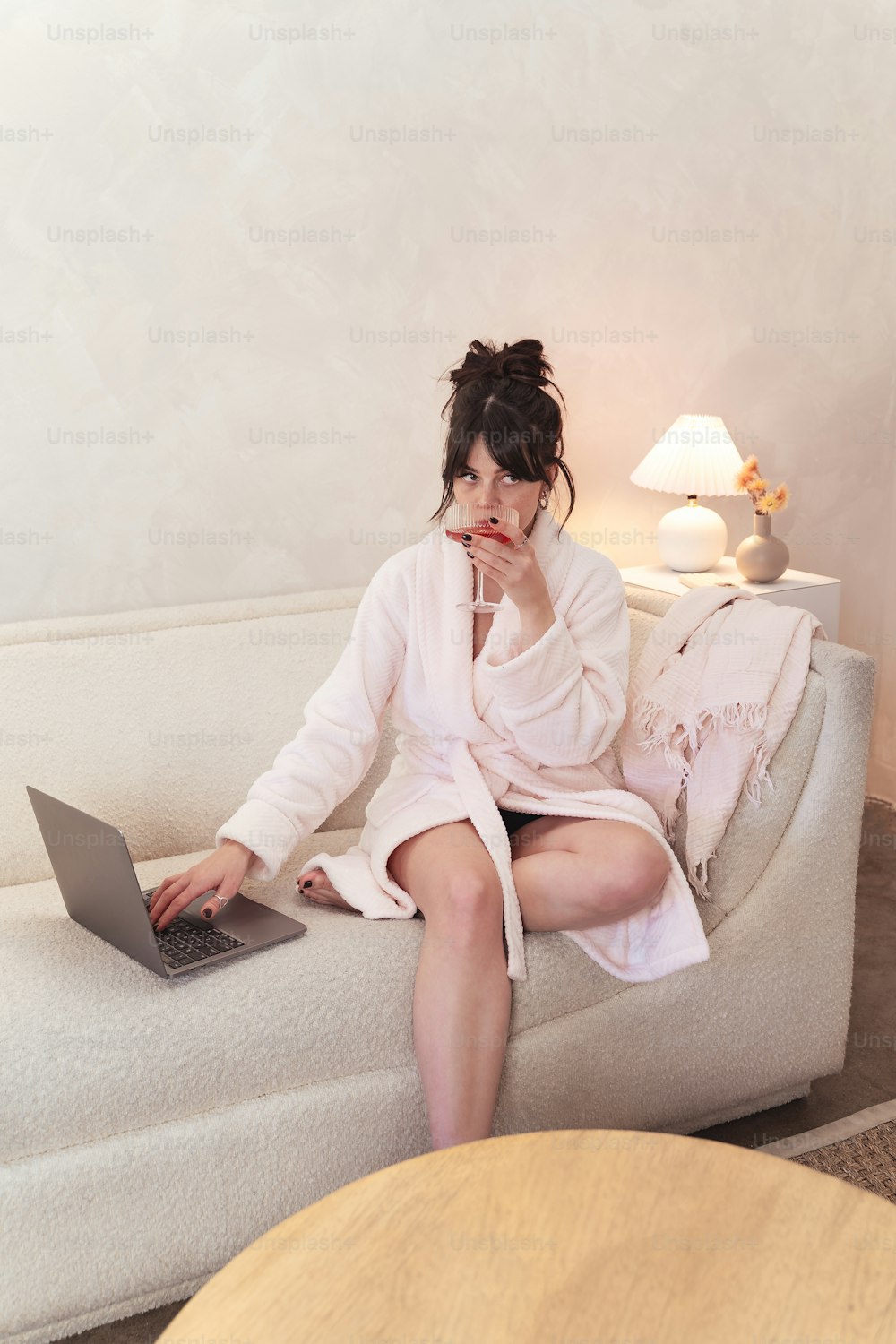 a woman sitting on a couch using a laptop computer