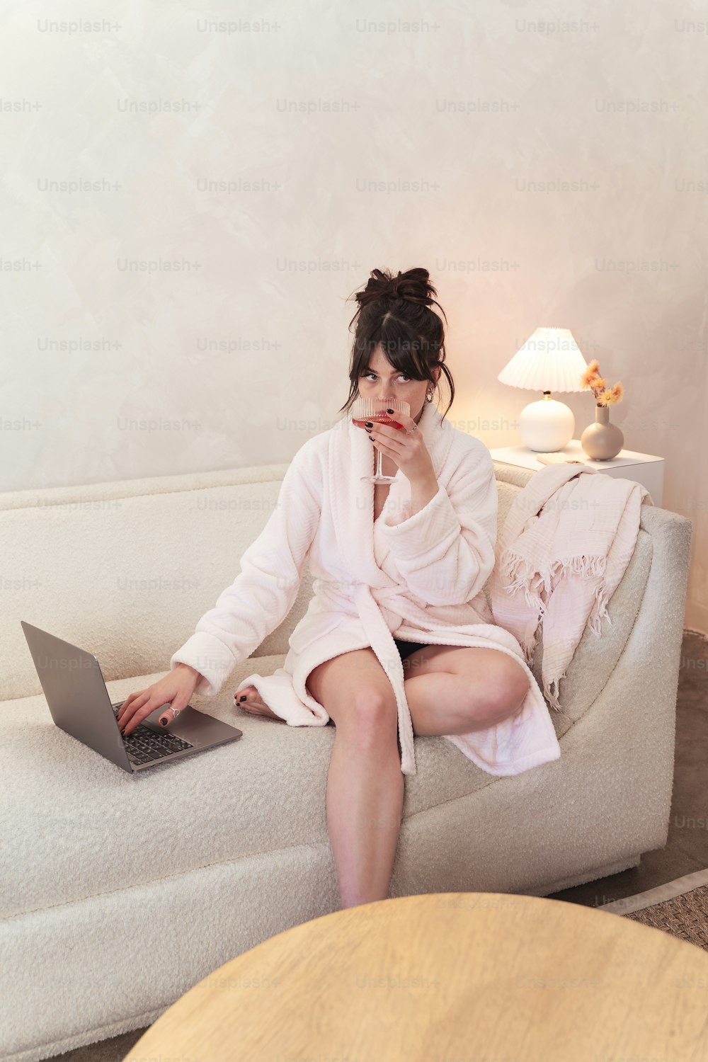 uma mulher sentada em um sofá usando um computador portátil