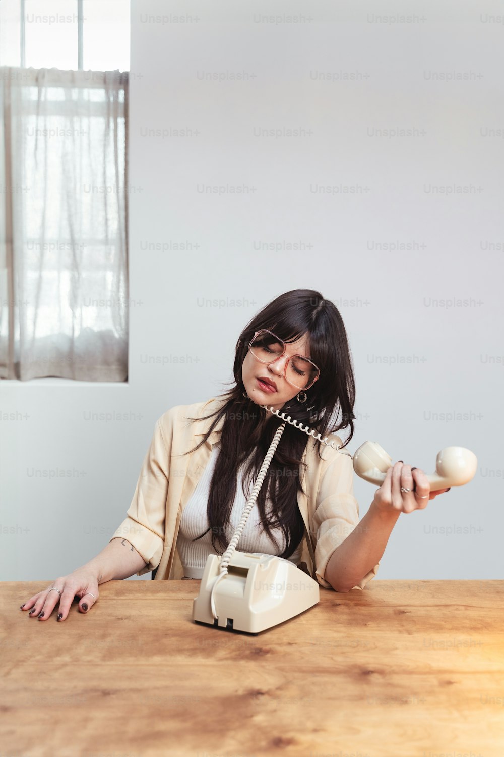 une femme assise à une table avec un objet à la main