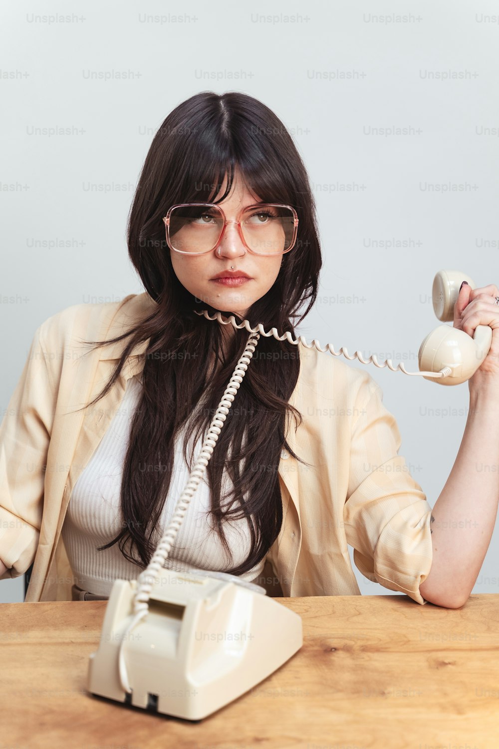 a woman sitting at a table talking on a telephone