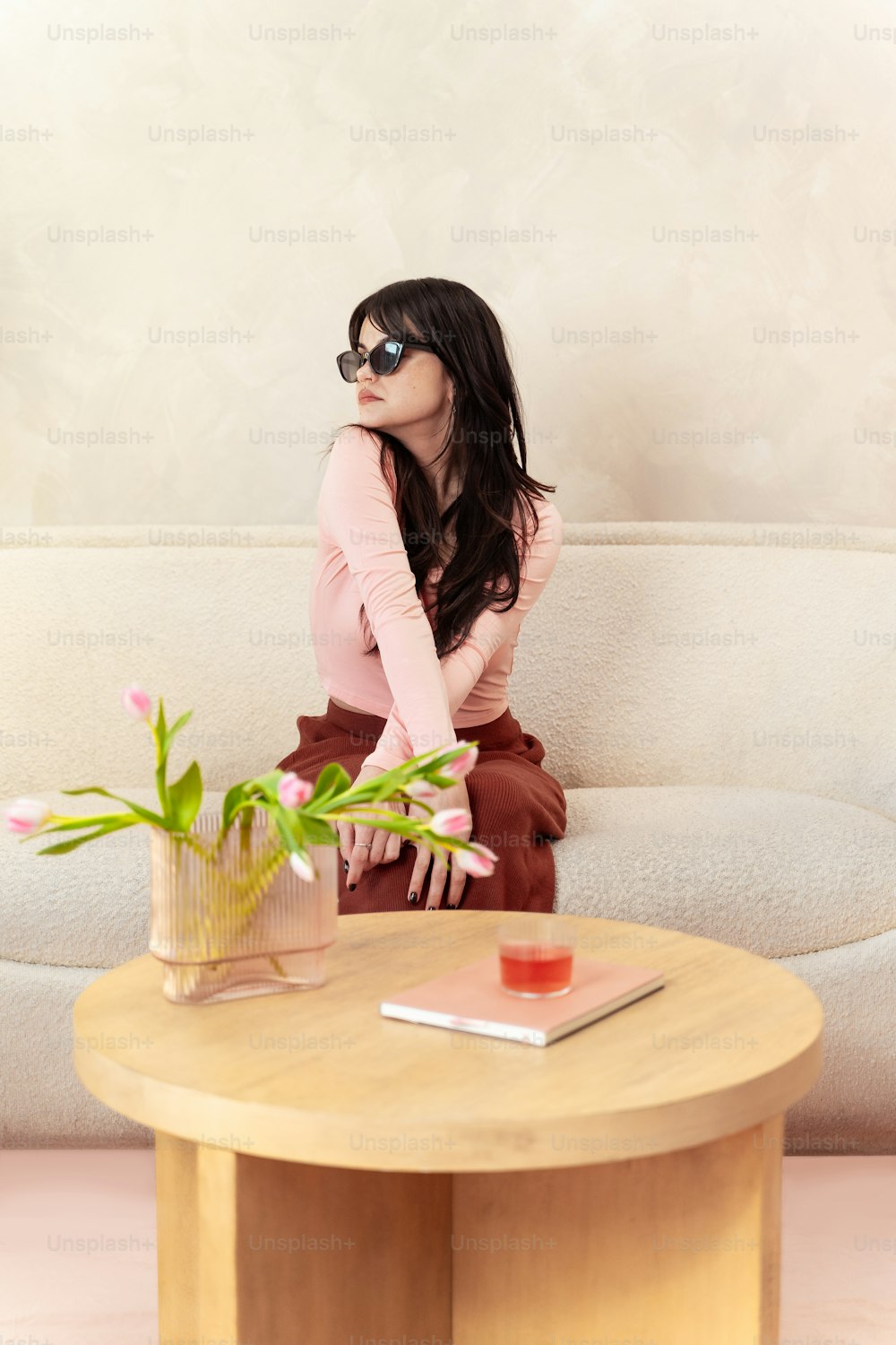 a woman sitting on a couch next to a table