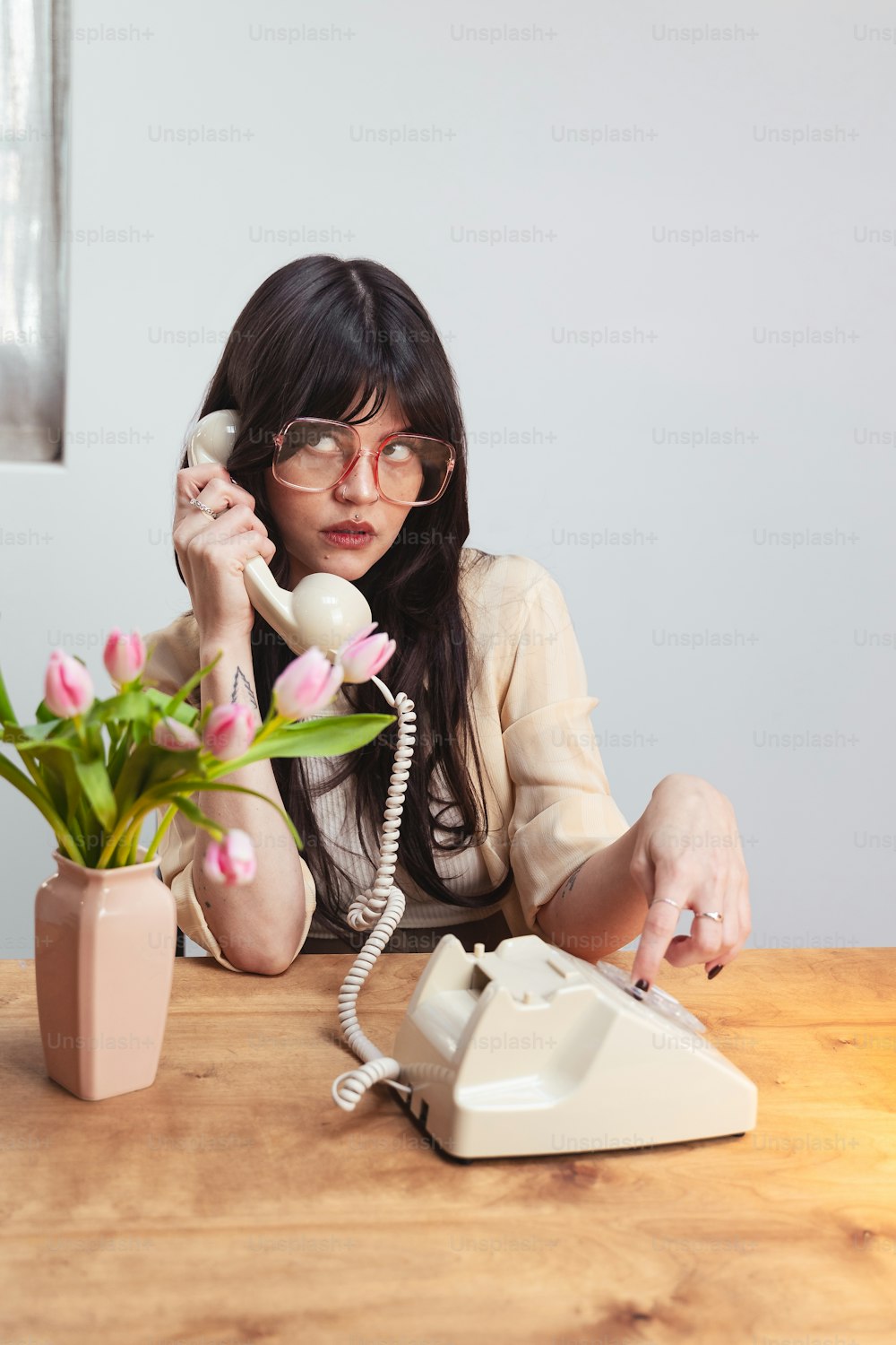 une femme assise à une table en train de parler au téléphone