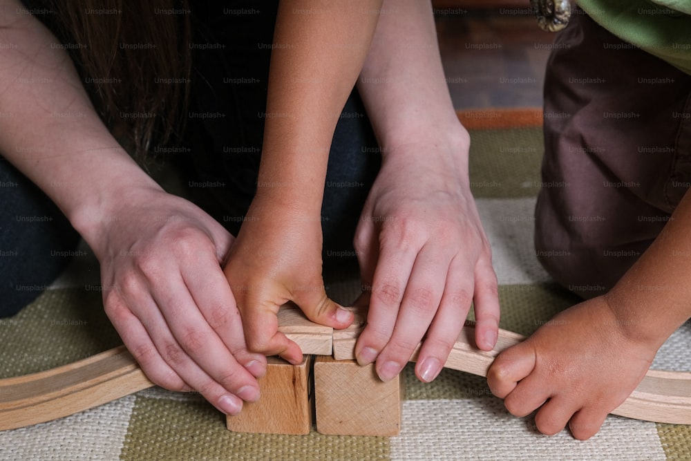 two children playing with wooden blocks on the floor