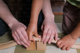 deux enfants jouant avec des blocs de bois sur le sol