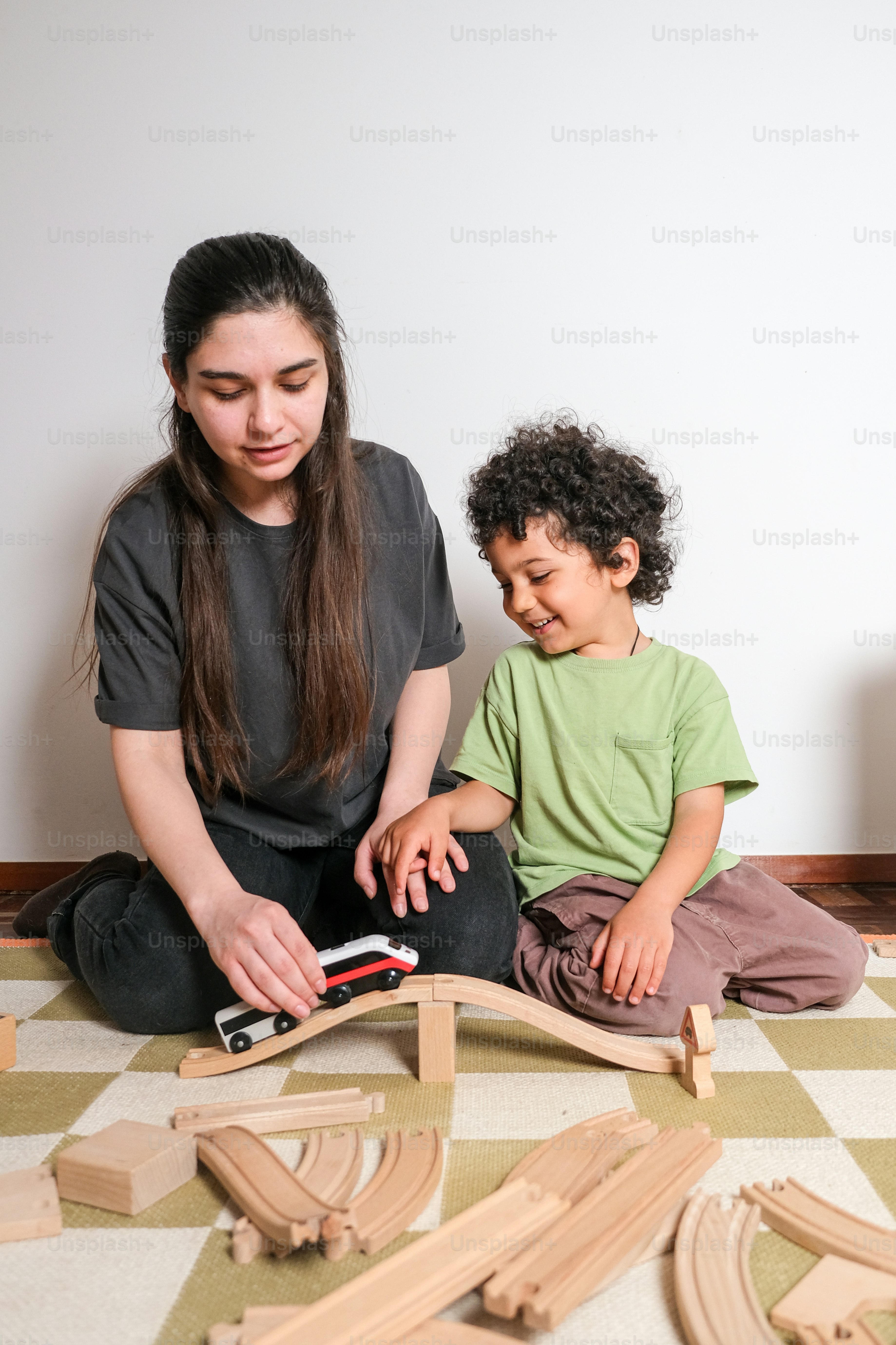 A woman playing with a child on the floor photo – Family Image on Unsplash