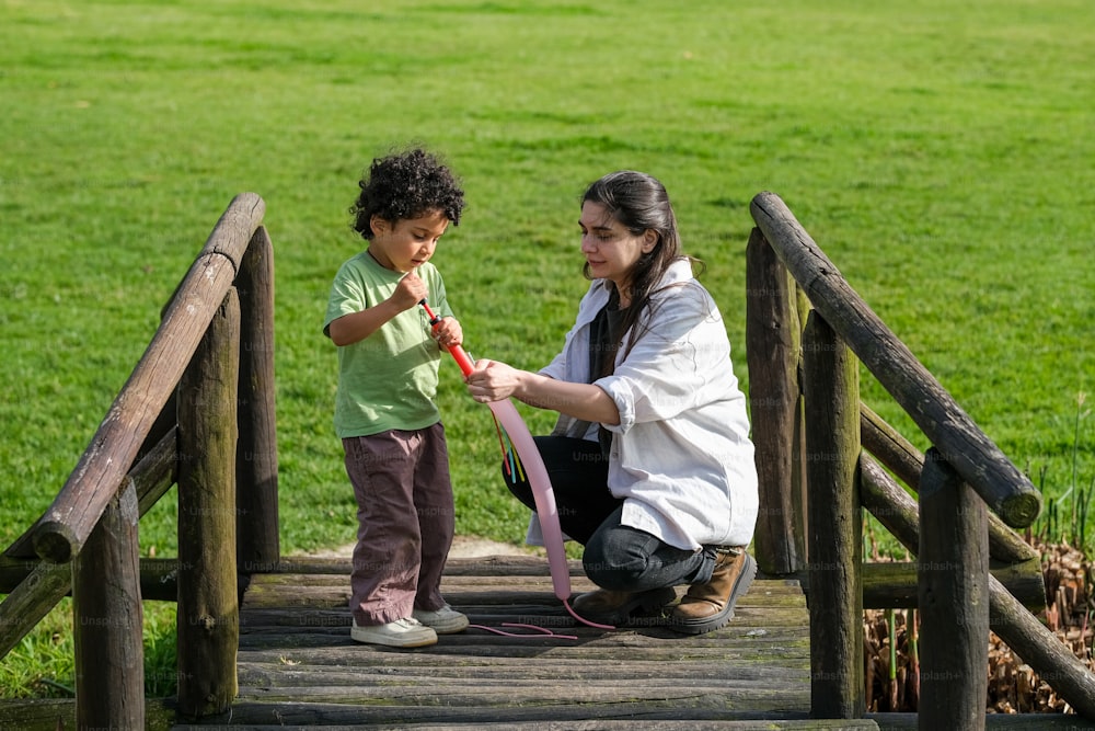 a woman and a child on a wooden bridge