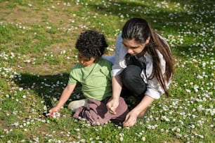 eine Frau, die neben einem Kind auf einem Blumenfeld kniet