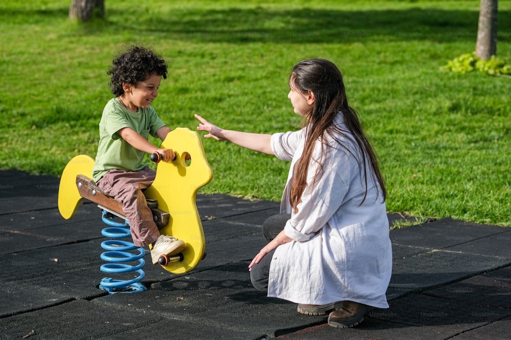 a woman and a child playing on a toy