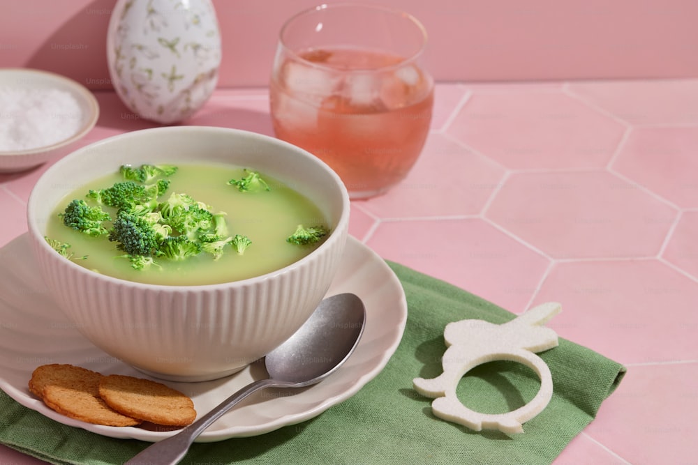 una ciotola di zuppa di broccoli su un piatto con un cucchiaio