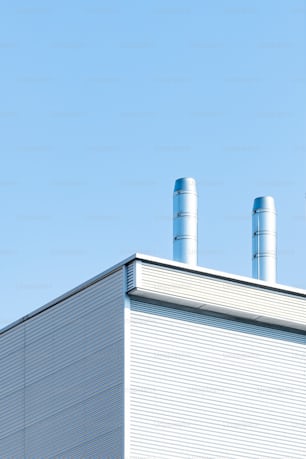 a white building with two blue smoke stacks on top of it