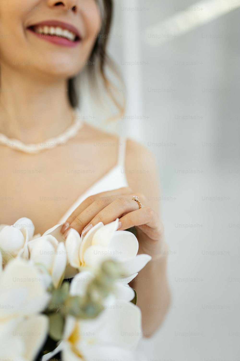 a woman holding a bouquet of white flowers