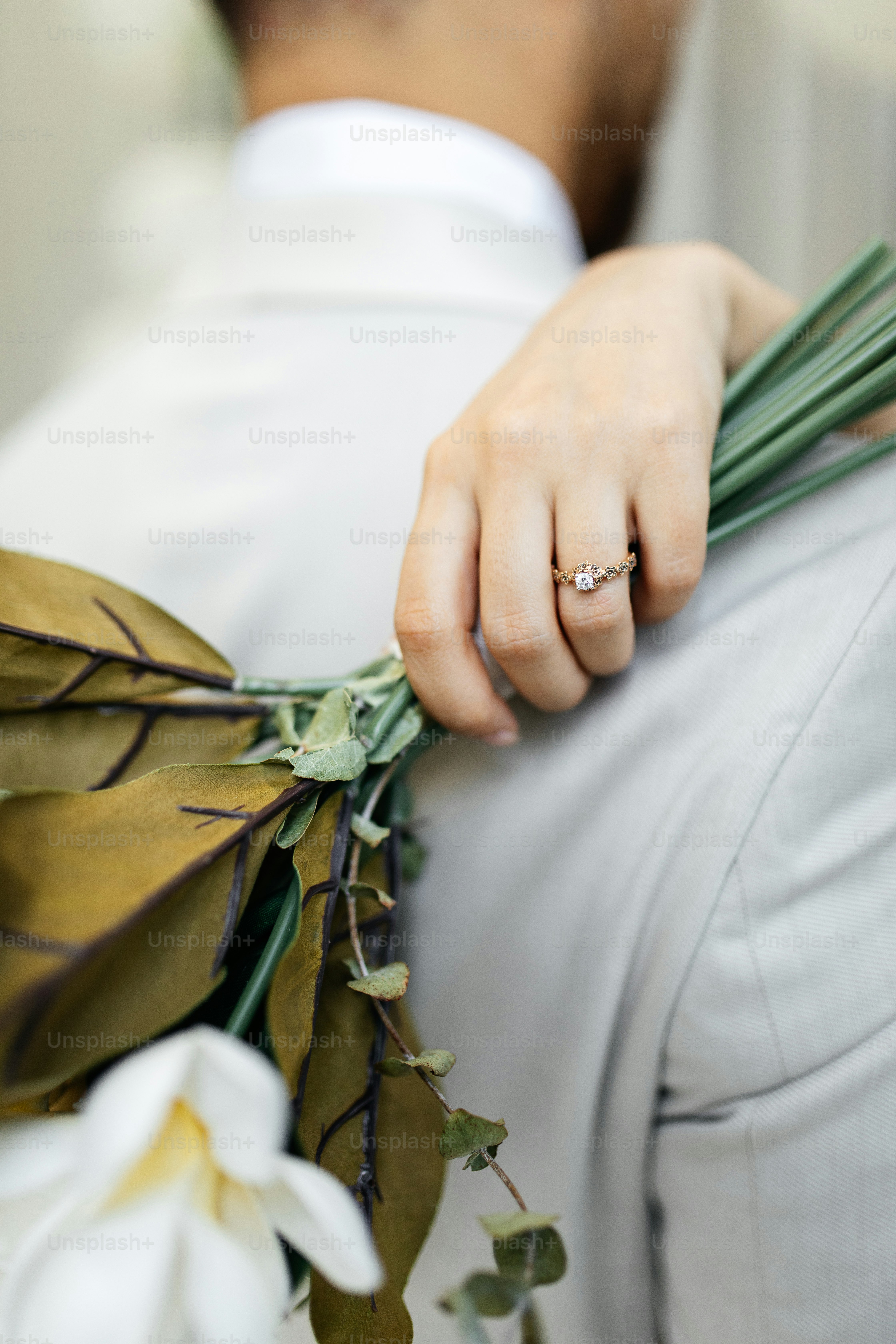 Une main portant une bague repose sur une épaule